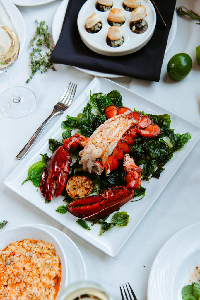 North Atlantic Whole Lobster on a bed of crispy spinach on a table with white table cloth